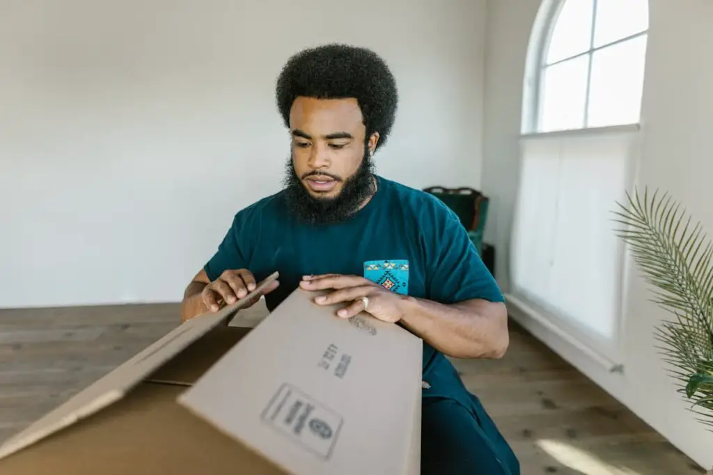 Man in Green Crew Neck T-shirt Holding White Printer Paper